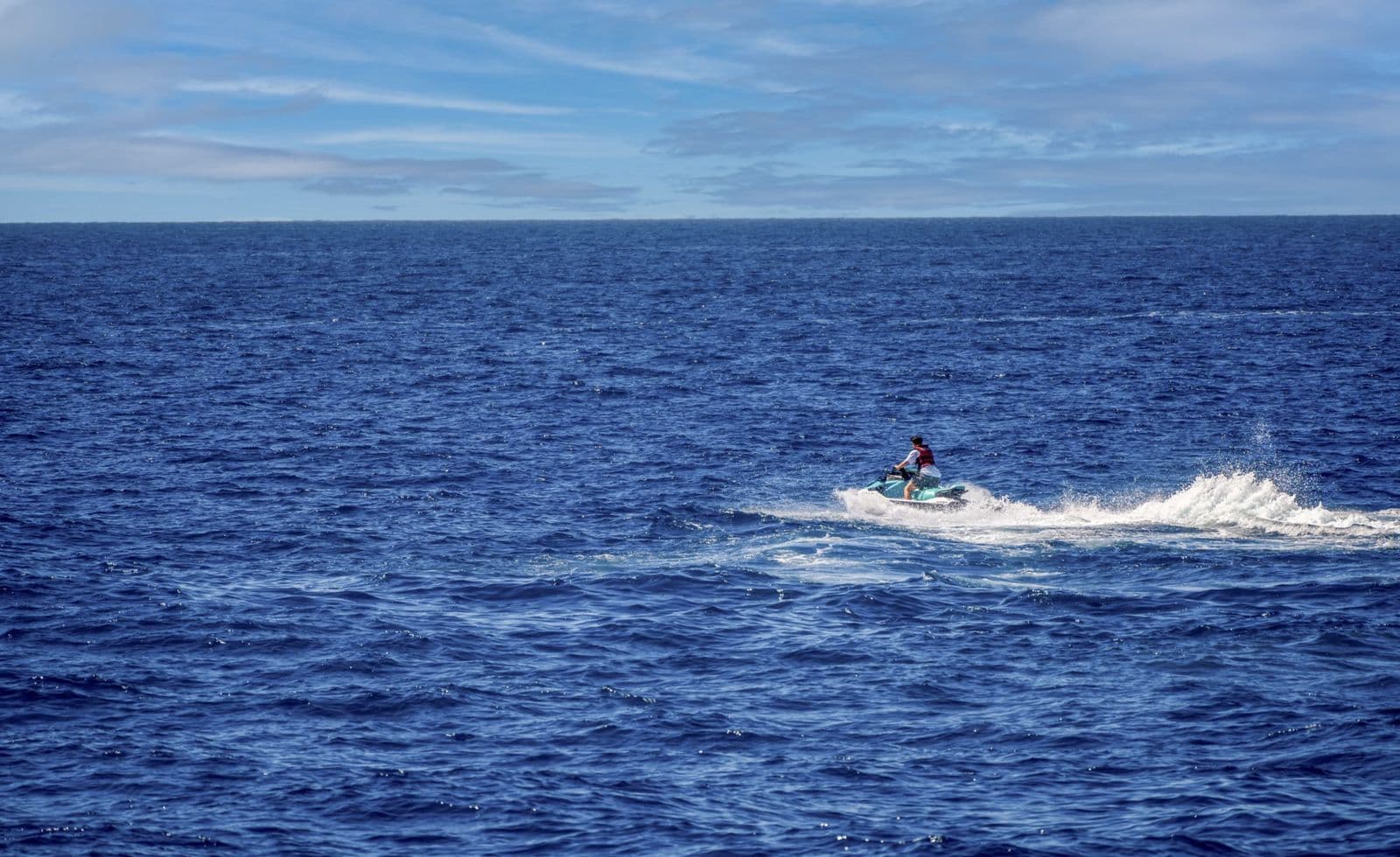 jetski rider in a red vest on the open ocean
