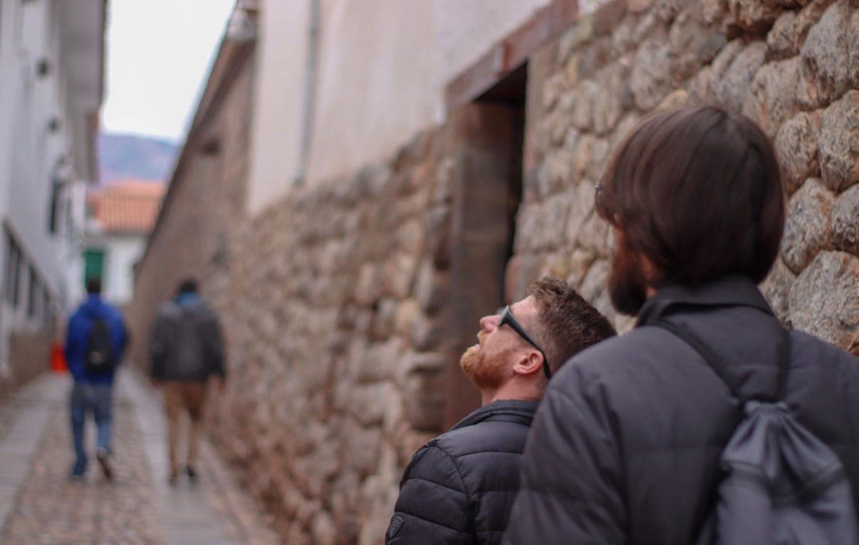 two guys in a cobblestone alley