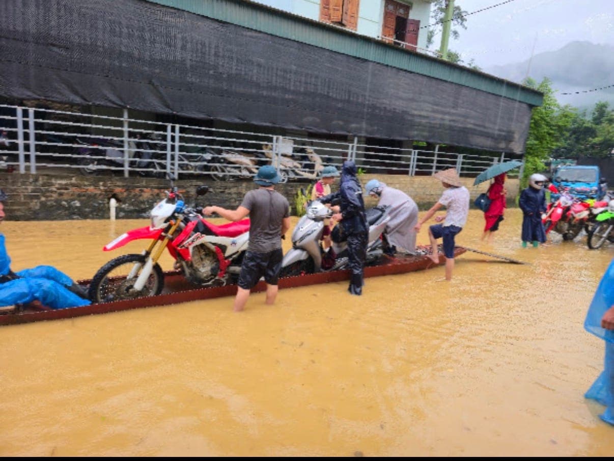 motos ferried in a boat through a flooded street