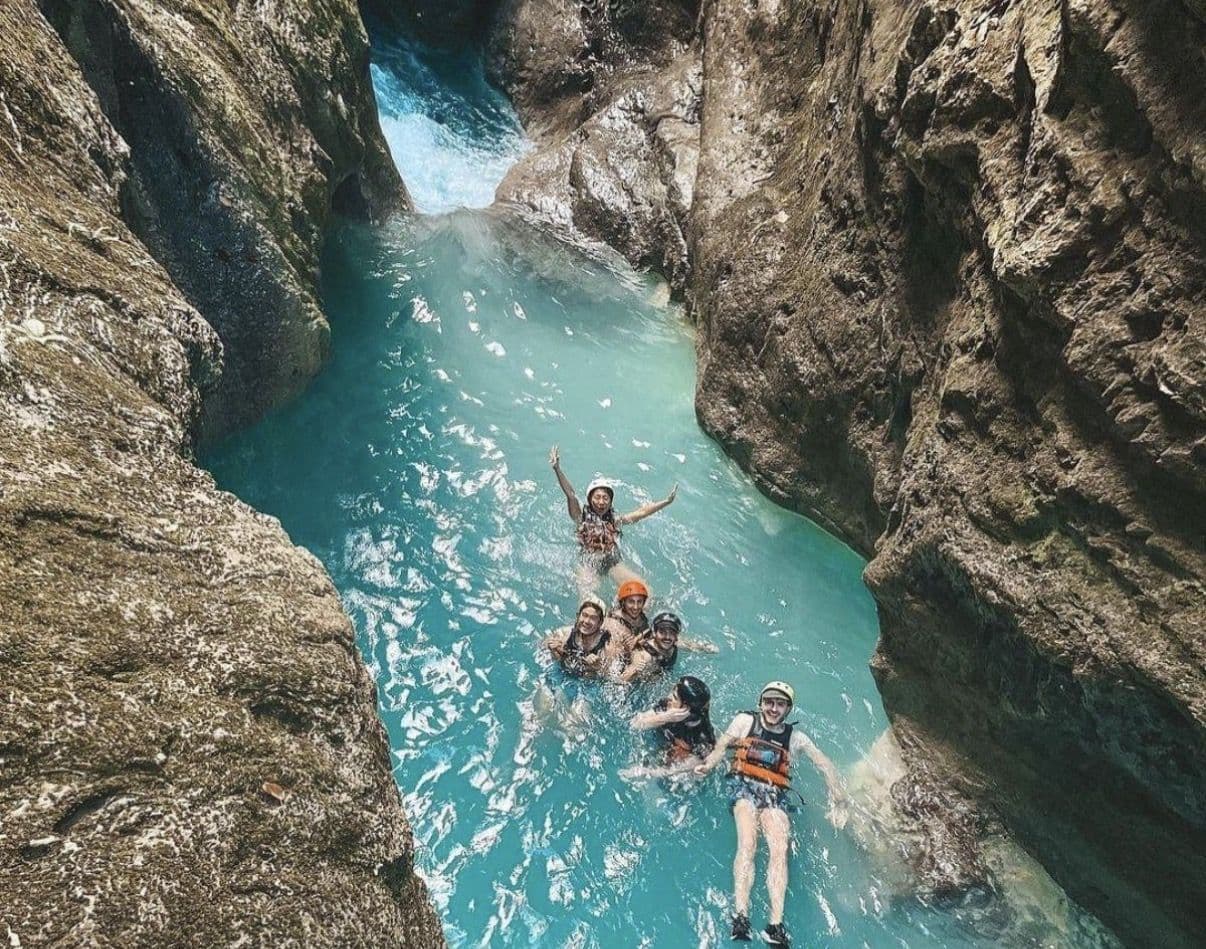 group in a canyon river, helmets and vests